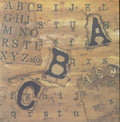 Design Originals Walnut ABCs 12x12 scrapbook paper with dramatic alphabet letter collage in typewriter and serif styles on torn paper layers in walnut brown and golden amber
